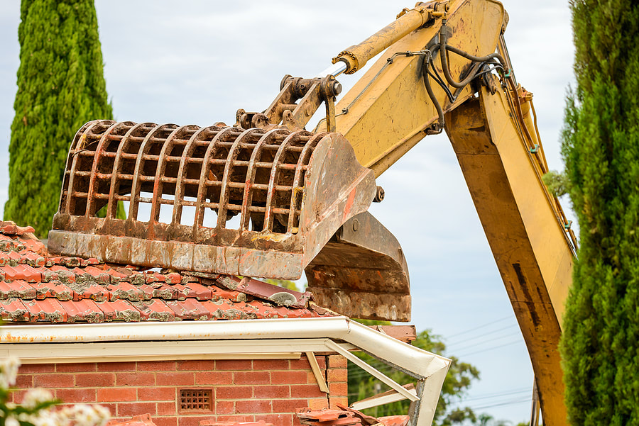 an excavator truck demolishing a house
